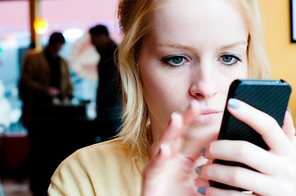 Image: A young woman uses a smart phone