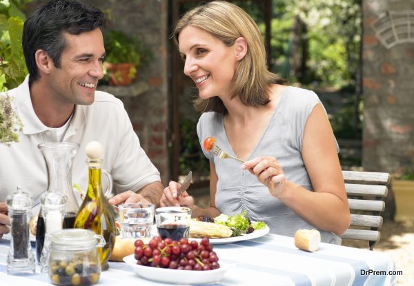 Couple eating lunch in garden, smiling