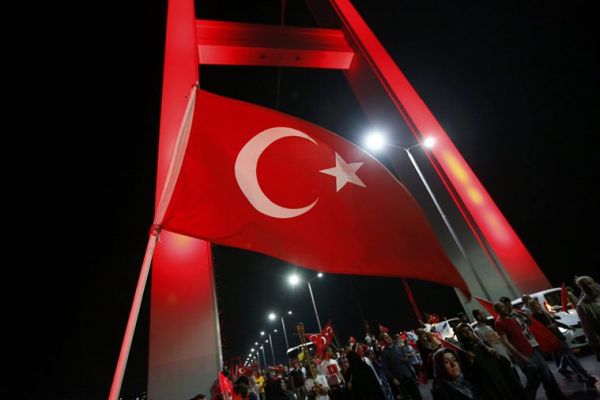A Turkish national flag waves as pro-government demonstrators march over the Bosphorus Bridge, from the Asian to the European side of Istanbul, Turkey, July 21, 2016. REUTERS/Murad Sezer